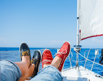Segler liegen mit ihren Bootsschuhen an Deck einer Yacht