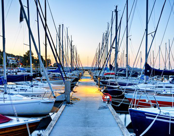 Charter-Beschlagnahmeversicherung: Segelboote im Hafen bei Sonnenuntergang
