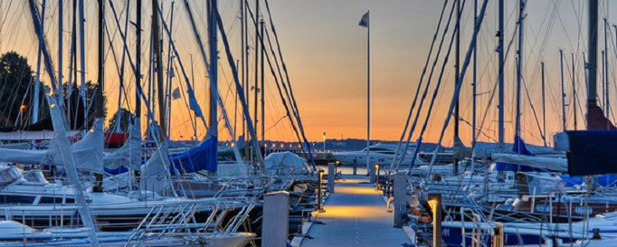 Reiserücktrittsversicherung: Segelboote im Hafen bei Sonnenuntergang